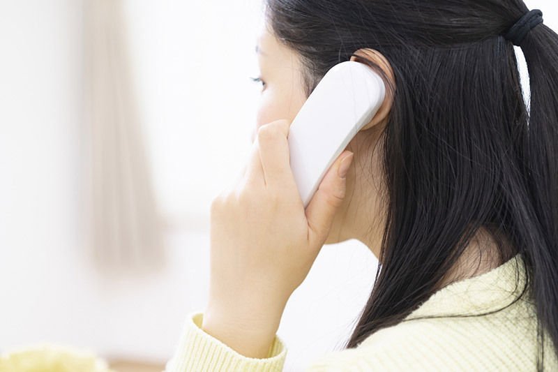 初めての方へ：電話をかける女性